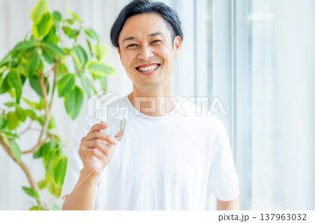 グラスに入った水を持つ男性 137963032