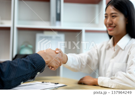 businessman shaking hands congratulating young woman who applied businessman shaking hands congratulating young woman who applied 137964249