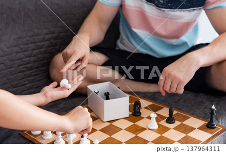 Father And Daughter Playing Chess At Home 137964311