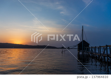桟橋の先に四手網漁の観察小屋が浮かぶ東郷湖と夕陽の風景 桟橋の先に四手網漁の観察小屋が浮かぶ東郷湖と夕陽の風景 137964810