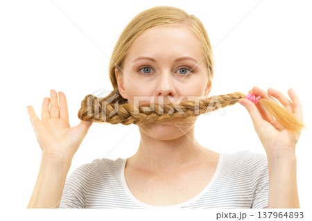 Blonde girl covering her mouth with braid hair 137964893