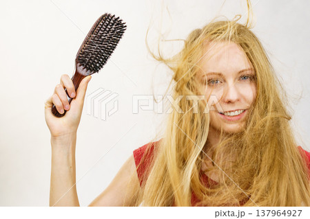 Blonde girl long blowing hair holds natural bristles brush Blonde girl long blowing hair holds natural bristles brush 137964927