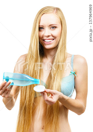 Woman cleaning her face skin with cotton pad Woman cleaning her face skin with cotton pad 137964969