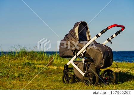Baby stroller outdoors on seashore. Baby stroller outdoors on seashore. 137965267