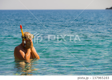 Man with snorkeling tube in sea 137965283