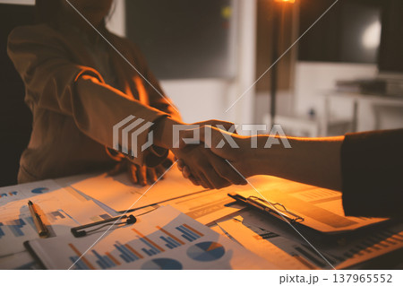 Two business people talk project strategy at office meeting room. Businessman discuss project planning with colleague at modern workplace while having conversation and advice on financial data report. 137965552
