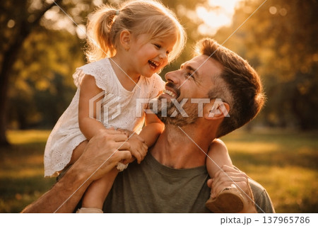 Happy Father Giving Daughter Shoulder Ride in Park at Sunset 137965786