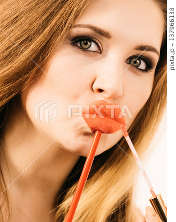 Woman applying lipstick or lip gloss Woman applying lipstick or lip gloss 137966138