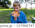 Young boy eating slice of pizza outdoors, close up, summer picnic, snack and fast food concept 137966747