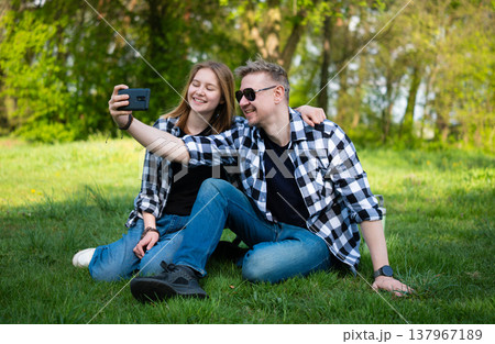 Happy Father And Daughter Taking Selfie With Smartphone On Grass 137967189