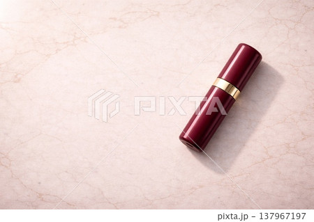 大理石天板に置かれた赤い円筒ボトルの上質な商品背景素材 137967197