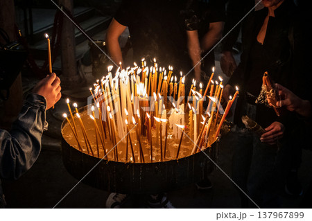 Christian pilgrims lighting candles in the Holy Sepulchre in Jerusalem. 137967899