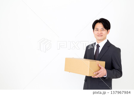 段ボールの荷物を持つミドル男性ビジネスマン 137967984