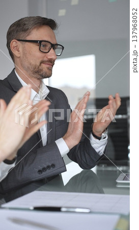 Business professional analyzing financial data with charts and graphs, discussing market trends, planning strategy, collaborating on corporate project in modern office, vertical view 137968052