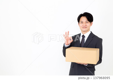 段ボールの荷物を持って丸のポーズをするミドル男性ビジネスマン 137968095