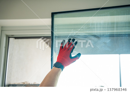 Removed triple glazed window glass unit leaning near frame after replacement in apartment. Broken insulated glass panel removal and window repair process concept. Removed triple glazed window glass unit leaning near frame after replacement in apartment. Broken insulated glass panel removal and window repair process concept. 137968346