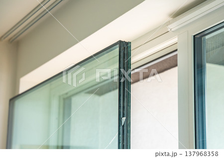 Removed triple glazed window glass unit leaning near frame after replacement in apartment. Broken insulated glass panel removal and window repair process concept. Removed triple glazed window glass unit leaning near frame after replacement in apartment. Broken insulated glass panel removal and window repair process concept. 137968358