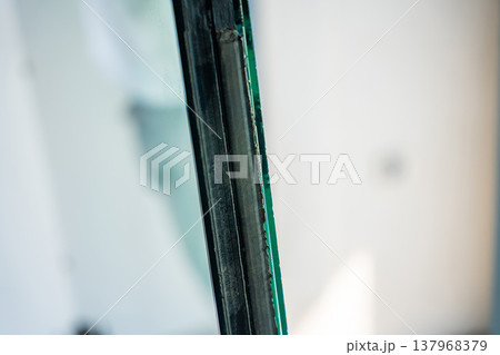 Edge detail of triple glazed window unit showing layered glass structure. Modern energy efficient window construction concept. Edge detail of triple glazed window unit showing layered glass structure. Modern energy efficient window construction concept. 137968379