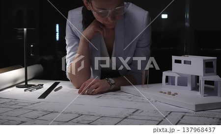 Female architect thinking about a modern house architecture project with blueprint and model on desk. Business and architect people concept Female architect thinking about a modern house architecture project with blueprint and model on desk. Business and architect people concept 137968437