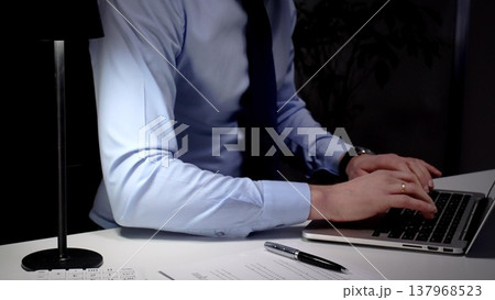Professional businessman typing on laptop, working late in an office, demonstrating dedication and diligence. Audit and taxes in business Professional businessman typing on laptop, working late in an office, demonstrating dedication and diligence. Audit and taxes in business 137968523