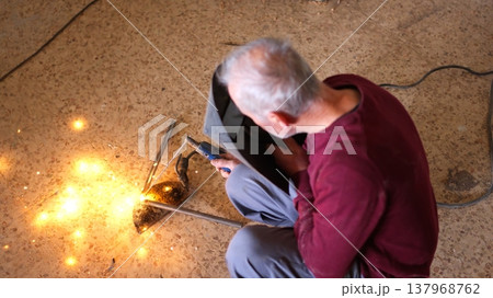 Man welding metal structure making bright sparks 137968762