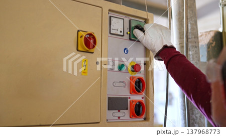 Worker in safety glove operating industrial machinery control panel Worker in safety glove operating industrial machinery control panel 137968773
