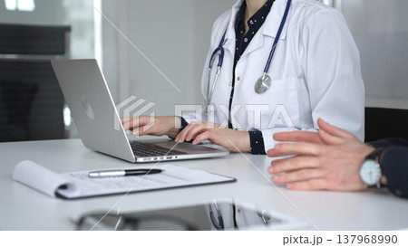 Doctor woman consulting male patient using laptop, discussing health information during medical examination at clinic office. Medicine, healthcare and science concept Doctor woman consulting male patient using laptop, discussing health information during medical examination at clinic office. Medicine, healthcare and science concept 137968990