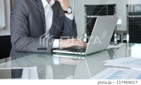 Businessman working on laptop in modern office, managing tasks, planning strategy, using digital technology. Business people concept Businessman working on laptop in modern office, managing tasks, planning strategy, using digital technology. Business people concept 137969027