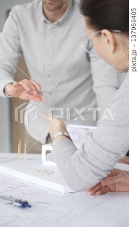 Architects are discussing building plans, using a compass over blueprints while collaborating on a new construction project in an office, emphasizing design, planning, and teamwork, close up Architects are discussing building plans, using a compass over blueprints while collaborating on a new construction project in an office, emphasizing design, planning, and teamwork, close up 137969405