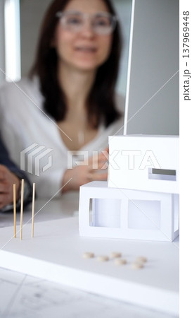 Architects and engineers collaborating on a project, analyzing construction blueprints with drafting tools during client meeting. Business people and architecture concept 137969448