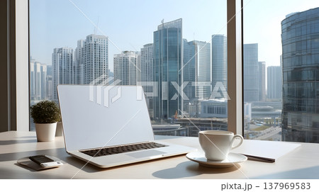 Modern office workspace with laptop coffee and city skyline visible through window 137969583