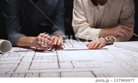 Architects and engineers collaborating on a building project, reviewing blueprints with a compass and divider, developing architectural plans and urban design strategies Architects and engineers collaborating on a building project, reviewing blueprints with a compass and divider, developing architectural plans and urban design strategies 137969977