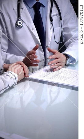 Doctor writing prescription during medical consultation, patient explaining symptoms, healthcare professional providing treatment plan, medical exam, health support Doctor writing prescription during medical consultation, patient explaining symptoms, healthcare professional providing treatment plan, medical exam, health support 137970113