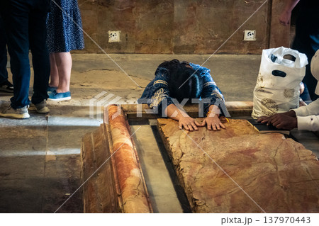 Christian pilgrims' hands on the Stone of Anointing, Holy Sepulchre. 137970443