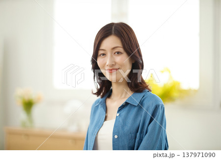 リビングでカメラ目線で微笑むミドルの女性 リビングでカメラ目線で微笑むミドルの女性 137971090