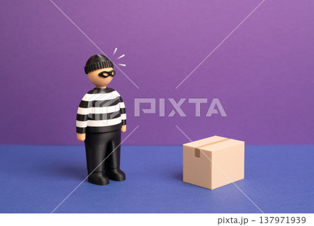 A criminal is interested in a package box. Parcel theft and delivery theft. Security risks in logistics and e commerce shipments. Protection of packages during transportation and doorstep delivery. 137971939
