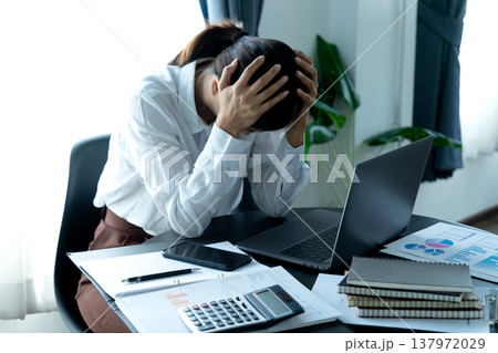 Businesswoman holding her head showing stressful headache Businesswoman holding her head showing stressful headache 137972029