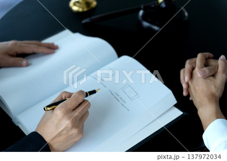 lawyer signing documents with female assistant handing lawyer signing documents with female assistant handing 137972034