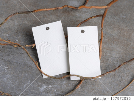 Blank gift tag mockup on grey stone with dry branches, copy space. Handmade product label 137972056