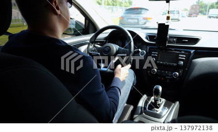 Confident man in sunglasses looking concentrated to urban road while riding automobile. Serious male driver driving a motor car at town. Guy operating the auto at highway. Slow motion 137972138