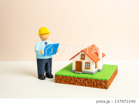 An engineer studies the house and land plans. Architectural analysis and project preparation for construction. Planning residential development and evaluating land plots before building begins. An engineer studies the house and land plans. Architectural analysis and project preparation for construction. Planning residential development and evaluating land plots before building begins. 137972240
