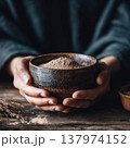 Hands Cradling Rustic Ceramic Bowl with Natural Herbal Powder 137974152