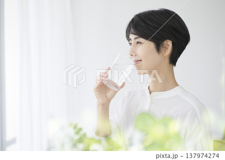 日常生活を送る若い女性 コップの水を飲む健康的な暮らし 137974274