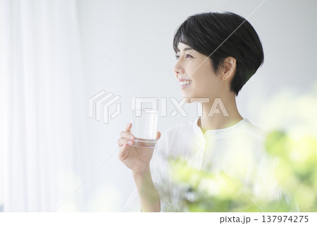 日常生活を送る若い女性 水を飲む朝の日課 日常生活を送る若い女性 水を飲む朝の日課 137974275