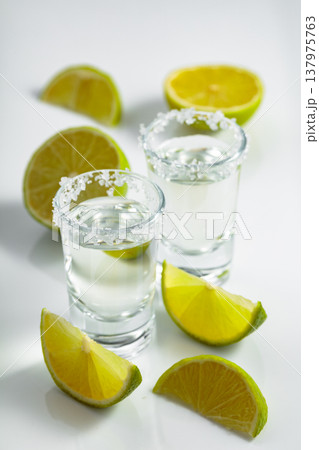 Tequila with salt and lime slices on a white table. 137975763