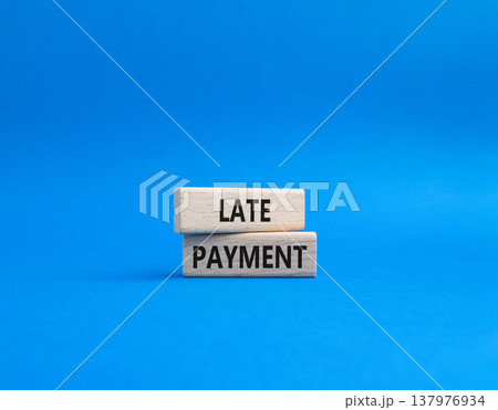 Late payment symbol. Concept word Late payment on wooden blocks. Beautiful blue background. Business and Late payment concept. Copy space 137976934
