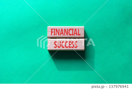 Financial success symbol. Concept word Financial success on wooden blocks. Beautiful green background. Business and Financial success concept. Copy space 137976941