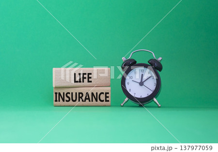 Life insurance symbol. Concept word Life insurance on wooden blocks. Beautiful green background with alarm clock. Business and Life insurance concept. Copy space Life insurance symbol. Concept word Life insurance on wooden blocks. Beautiful green background with alarm clock. Business and Life insurance concept. Copy space 137977059