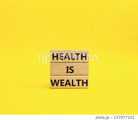 Health is Wealth symbol. Concept word Health is Wealth on wooden blocks. Beautiful yellow background. Medicine and Health is Wealth concept. Copy space 137977101