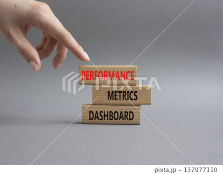 Performance metrics dashboard symbol. Concept word Performance metrics dashboard on wooden blocks. Businessman hand. Beautiful grey background. Business and Performance metrics dashboard. Copy space 137977110